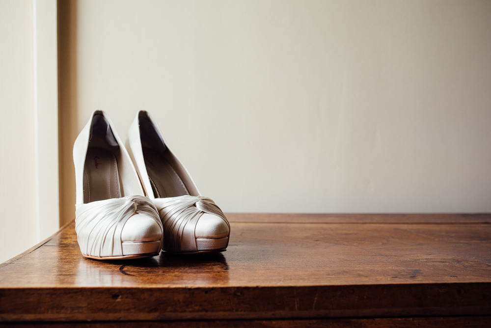 Caswell House Wedding Photography Bride's heels on wooden table