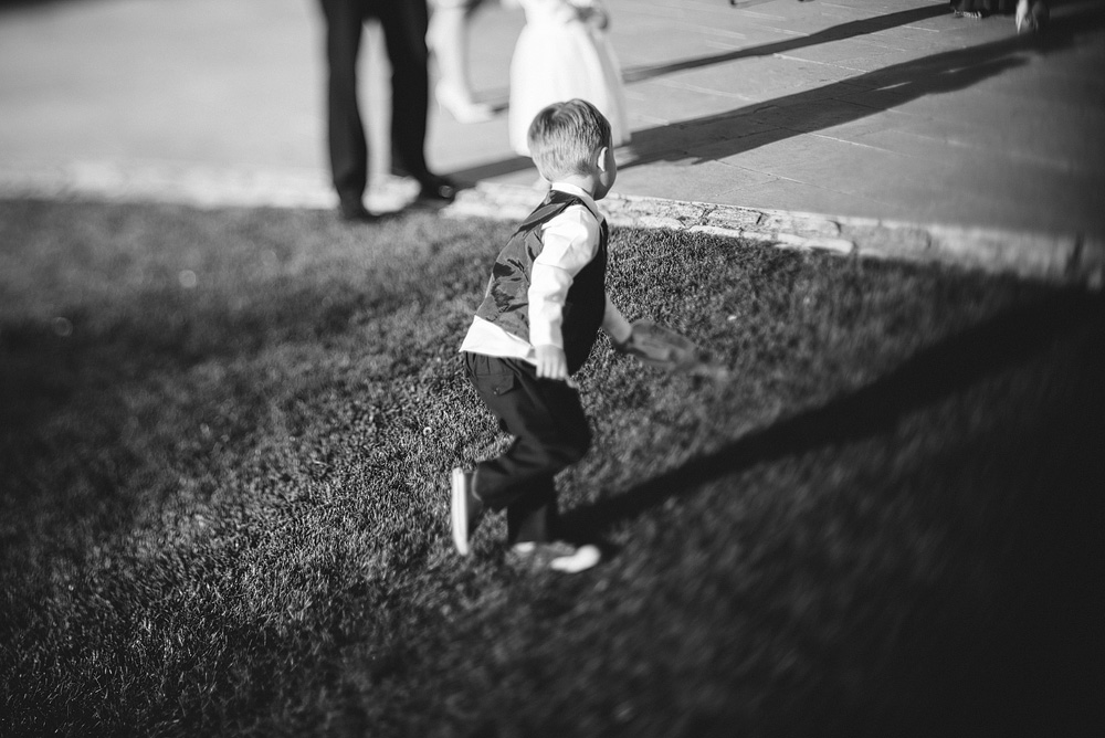 Black and white photo of boy running through grass