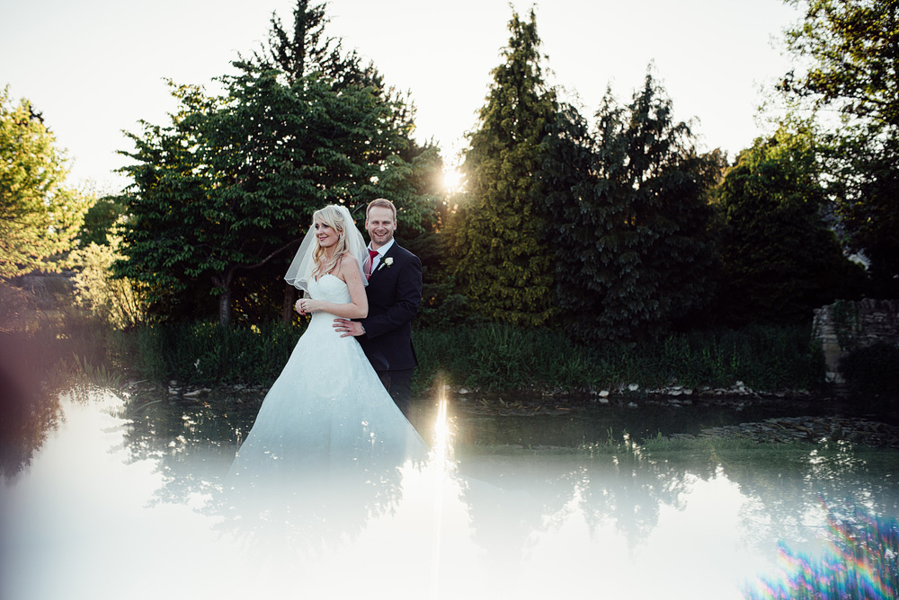 Overexposed photo, bride and groom smiling outside beside lake