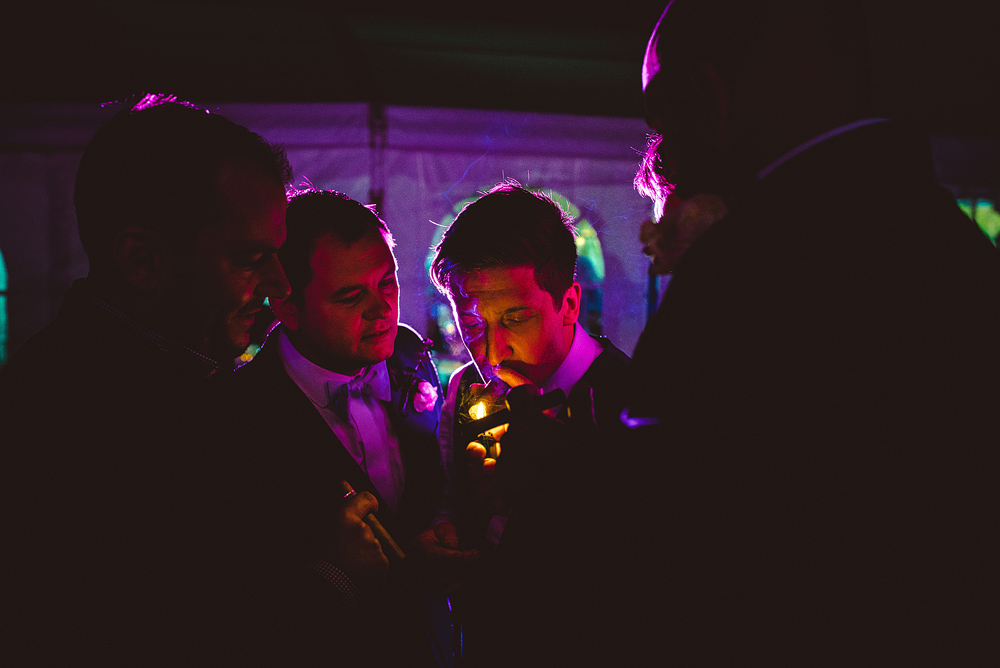 groom smoking cigar at wedding