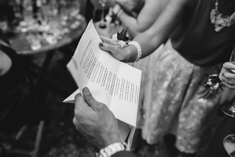 guests reading song lyrics at reid rooms wedding