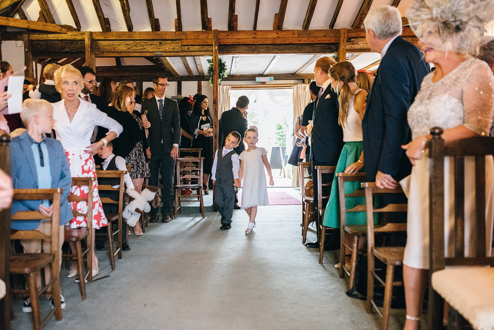 Boy and girl walking down aisle at wedding ceremony