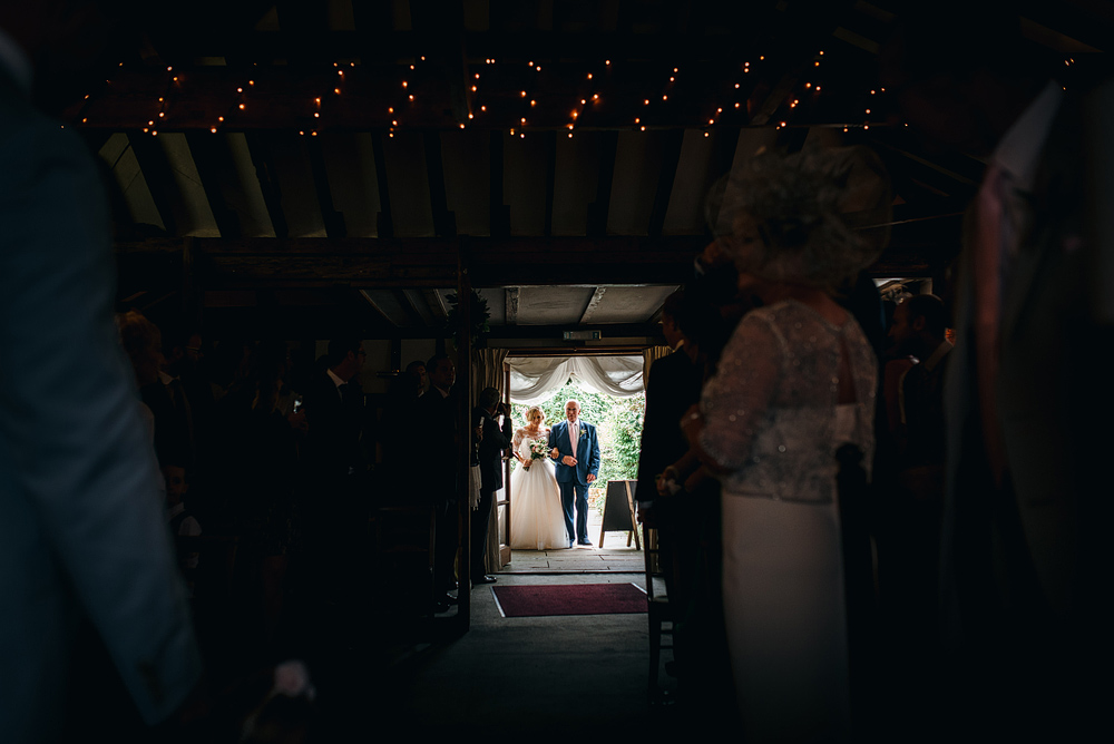 Father and bride walking into wedding ceremony together