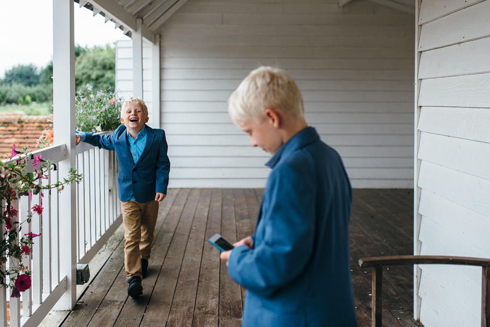 Little boys laughing on porch outside wedding reception