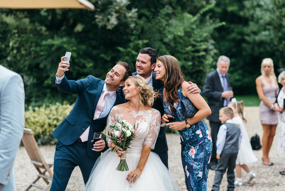 Bride and wedding guests snapping selfie