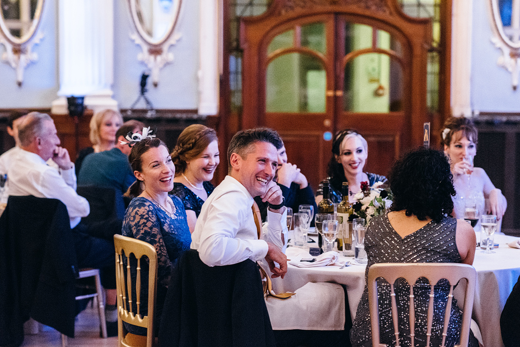 Wedding guests laughing at reception table