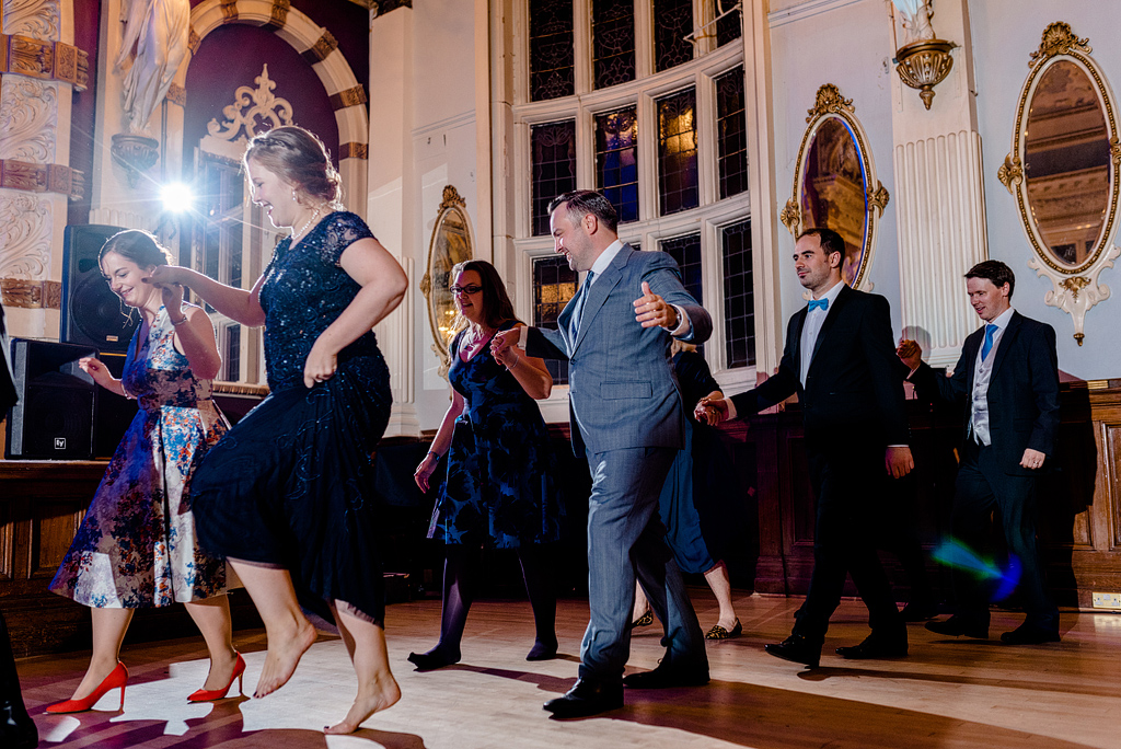 Wedding guests walking and dancing in formation at reception