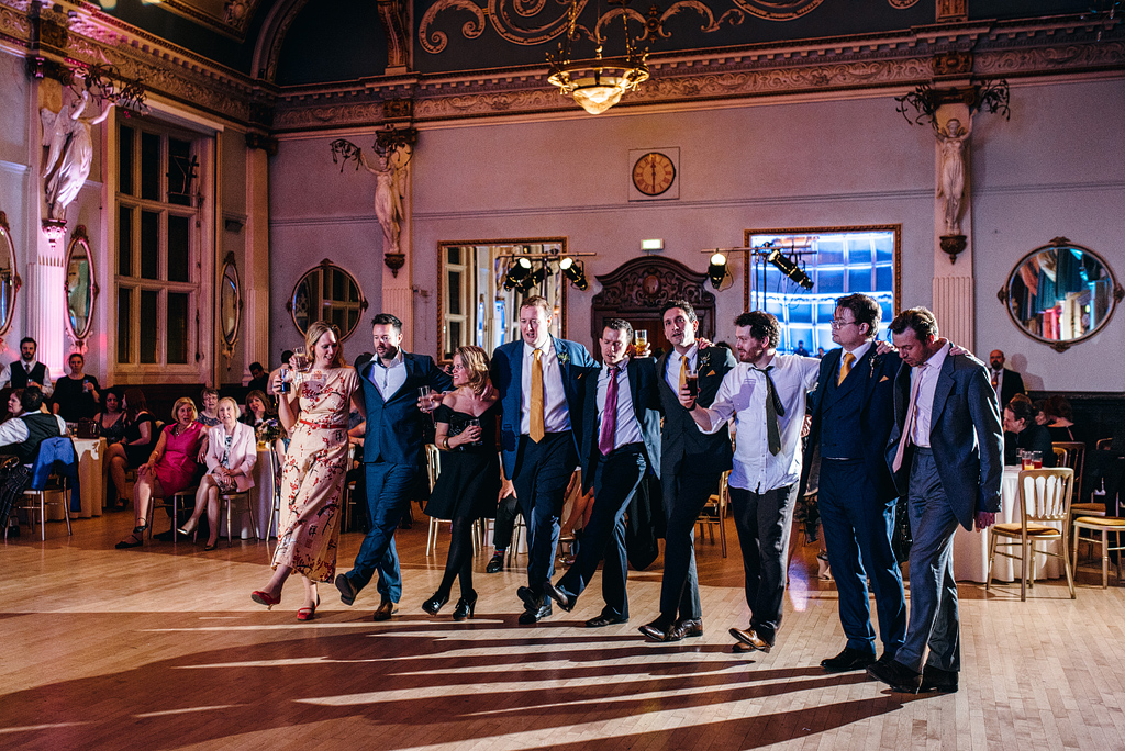 Wedding guests dancing in line at reception