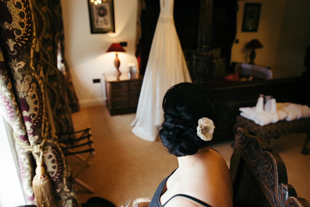 Bride looking at dress across room, preparing for wedding