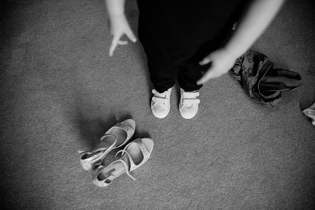 Child pointing down to bride's empty shoes