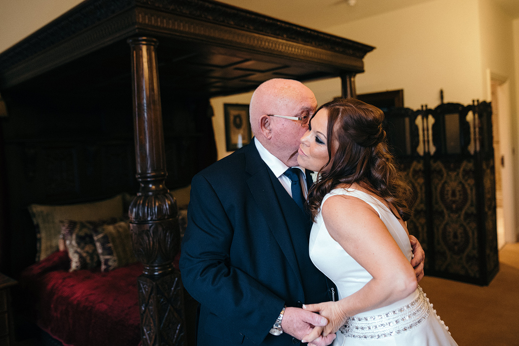 Proud father kissing bride before wedding ceremony