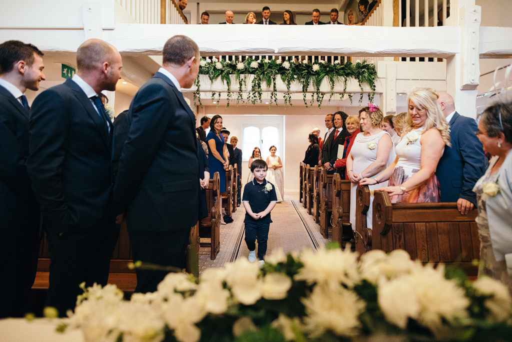 Small boy walks down wedding aisle
