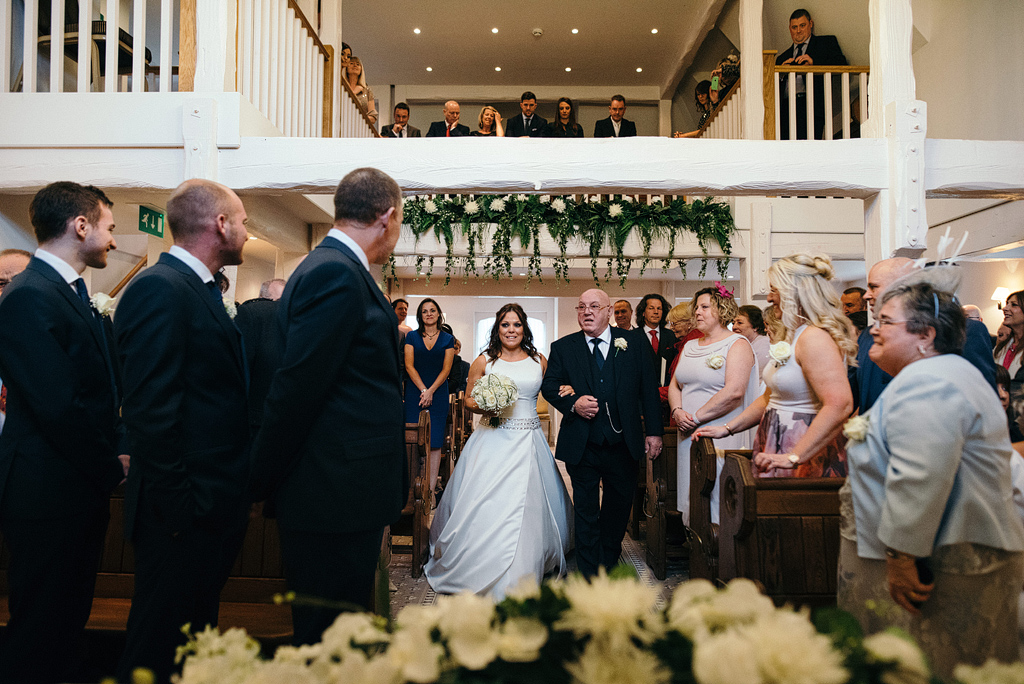 Father and bride walking down aisle at Orsett Hall Chapel