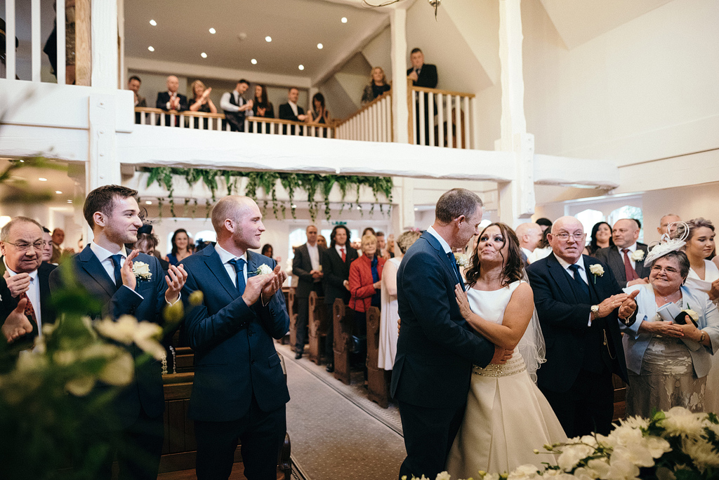 Guests applauding at new bride and groom