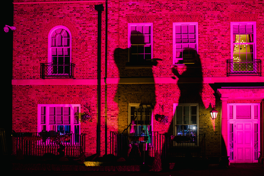 Silhouette of wedding guests, pink lighting at Orsett Hall Hotel