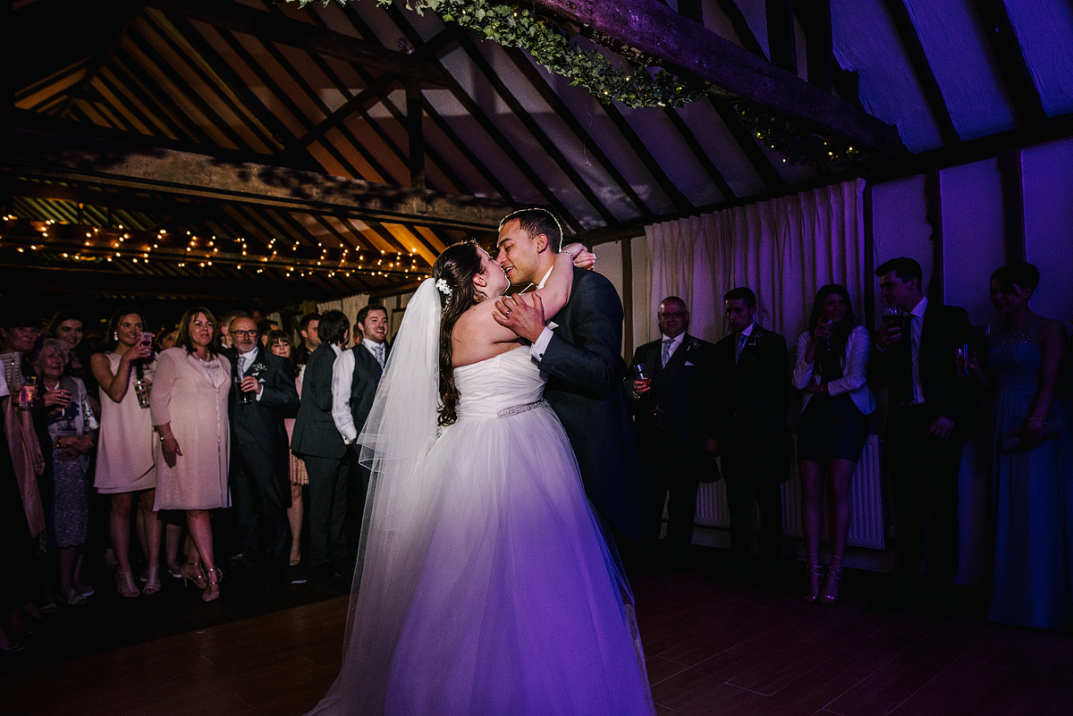 Bride and groom share a kiss while dancing