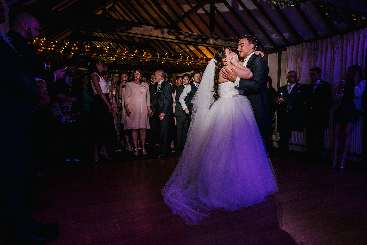 Bride and groom dancing while bride covers face