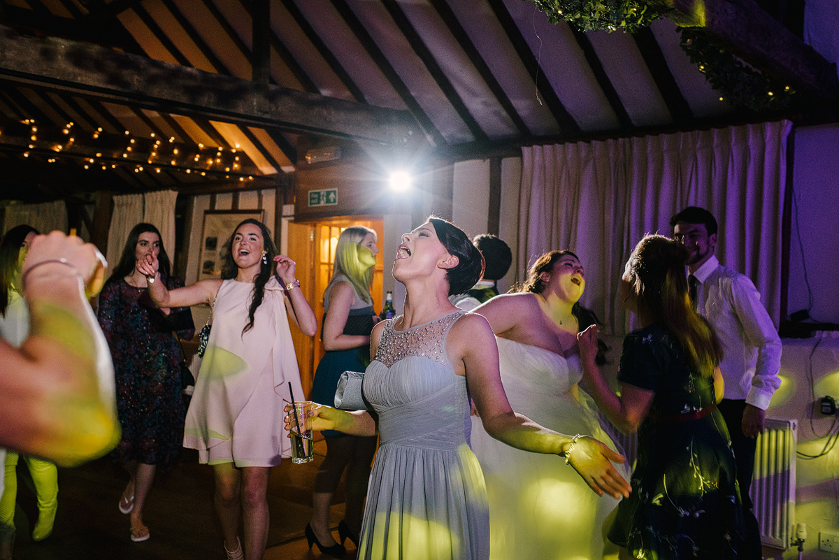 Guests singing and dancing with green lights overhead