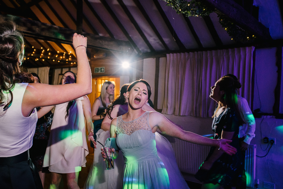 Bridesmaid singing and dancing with green lighting overhead