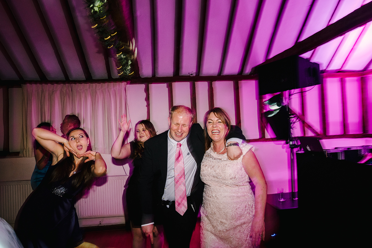 Guests laughing making silly faces under pink lighting