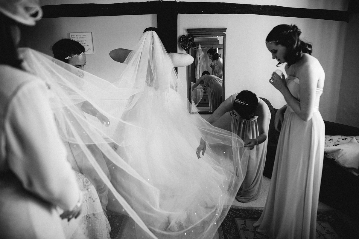 Veil and train being placed on bride