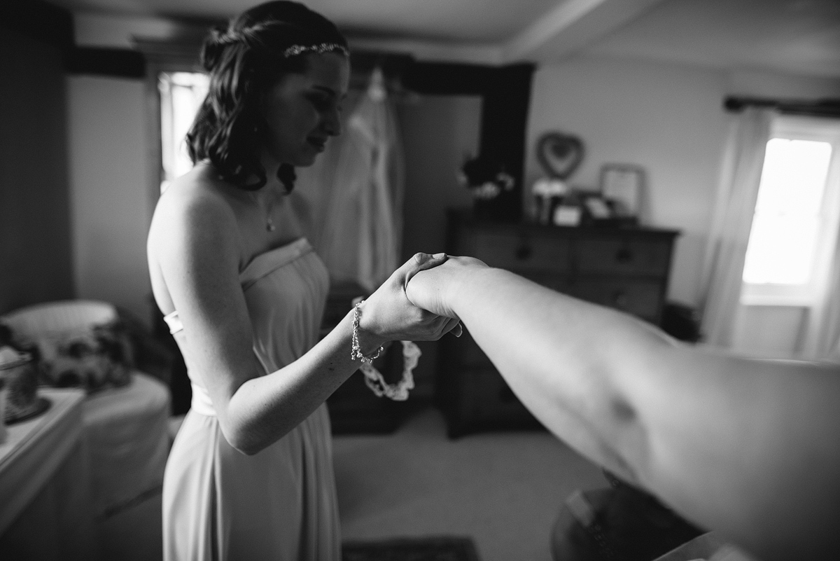 Bridesmaid holding bride's hand