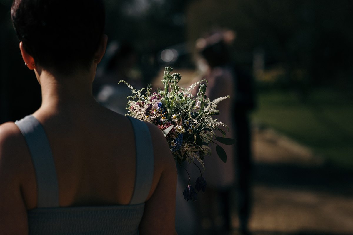 Bridesmaid, back to front, holding bouquet