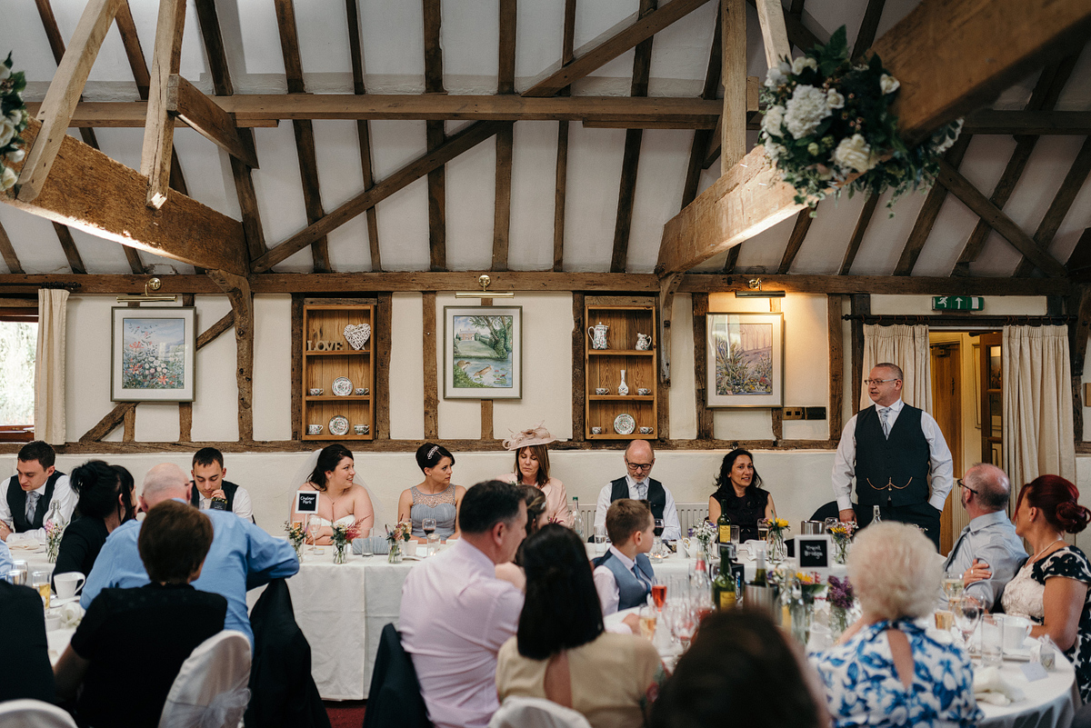 Father of bride giving speech at head of reception table