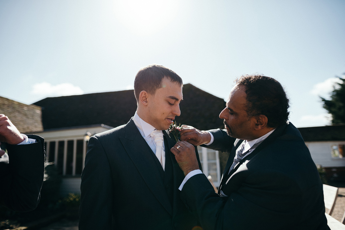 Father putting Boutonniere on groom's suit